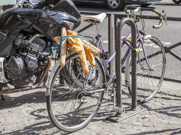 PARIS, FRANCE, on AUGUST 26, 2015. French baguettes on a luggage carrier of the old bicycle standing on a parking