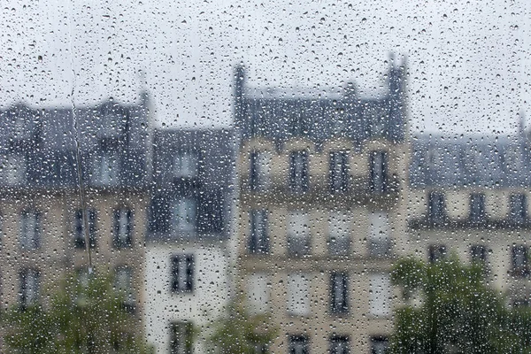 PARIS, FRANCE, on AUGUST 27, 2015. A fragment of an architectural complex of the square in front of the Centre Georges Pompidou, a look through a wet window. It is raining, water drops on glass