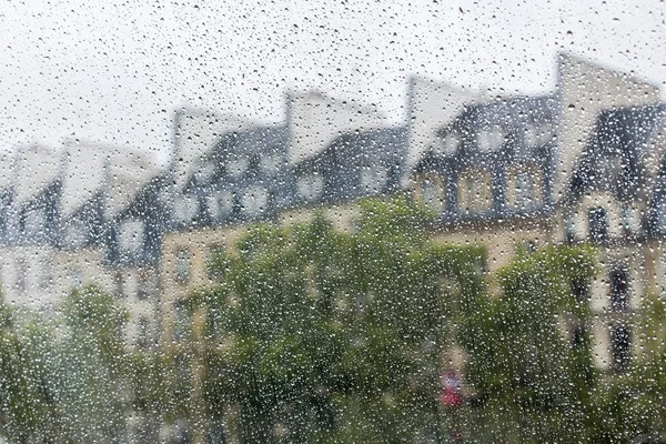PARIS, FRANCE, on SEPTEMBER 29, 2015. Parisian landscape. A view of city roofs through a wet window during a rain