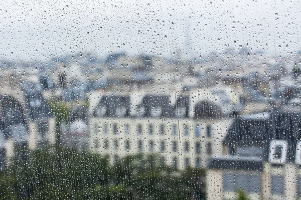 PARIS, FRANCE, on SEPTEMBER 27, 2015. A view of the city from a window from a high point during a rain. Rain drops on glass. Focus on drops