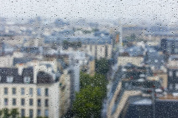 PARIS, FRANCE, on SEPTEMBER 27, 2015. A view of the city from a window from a high point during a rain. Rain drops on glass. Focus on drops