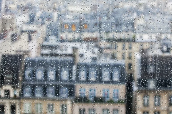 PARIS, FRANCE, on SEPTEMBER 29, 2015. Parisian landscape. A view of city roofs through a wet window during a rain