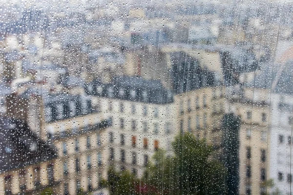 PARIS, FRANCE, on AUGUST 31, 2015. The top view from a survey platform on roofs of Paris through wet glass during a rain