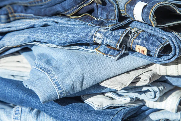 Pile of jeans of various shades on a show-window of shop