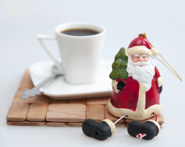 Cup with black coffee and Father Frost\'s figure