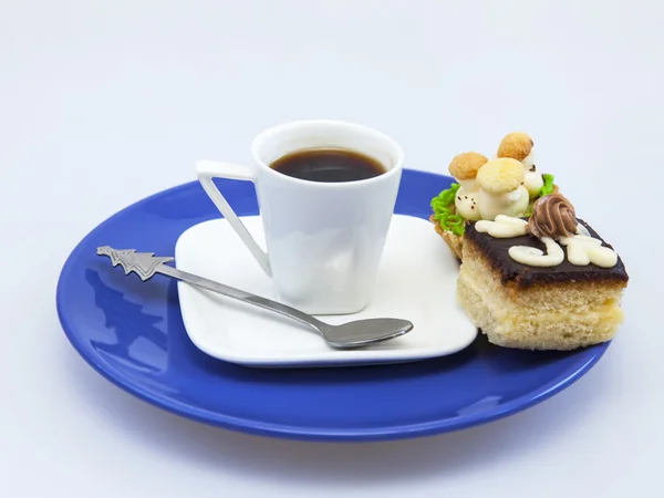 Cup with black coffee and a plate with cakes