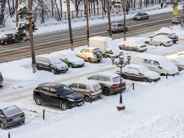 PUSHKINO, RUSSIA, on JANUARY 24, 2016. Winter city landscape. A view of a street parking and the cars covered with snow.