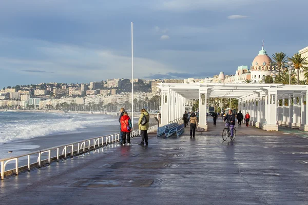 NICE, FRANCE - on JANUARY 8, 2016. View of the line of a surf, wave, beach and sky. People are walking along the sea on the embankment