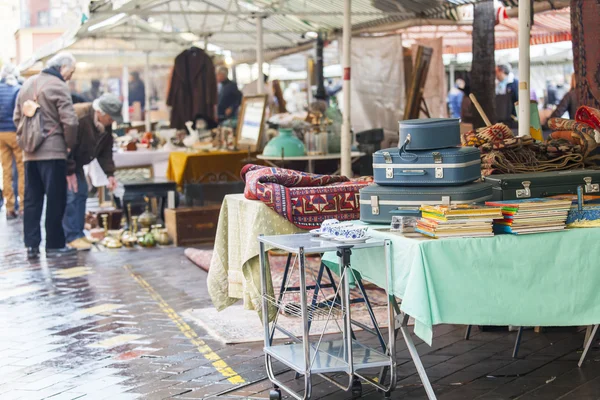 NICE, FRANCE - on JANUARY 11, 2016. Goods, sellers and buyers in a flea market on Cours Saleya Square