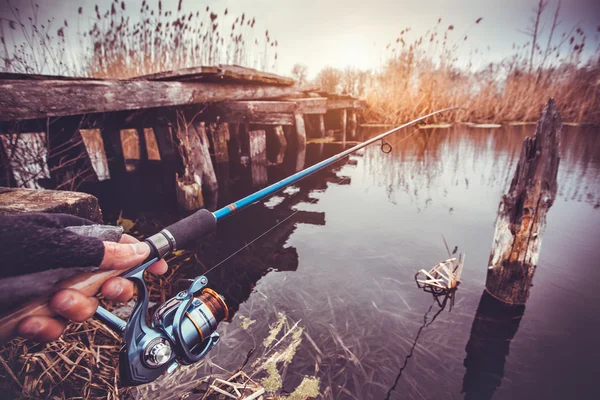 Man holding spinning rod on the river. fishing