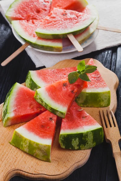 Healthy watermelon on the black wooden background.