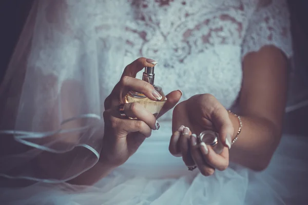 Bride applying perfume on her wrist