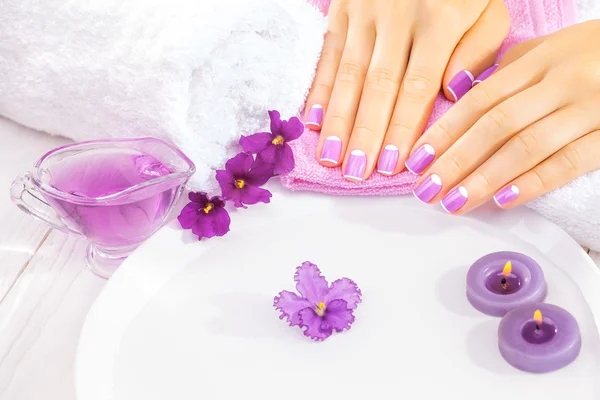 French manicure with violet flowers. spa