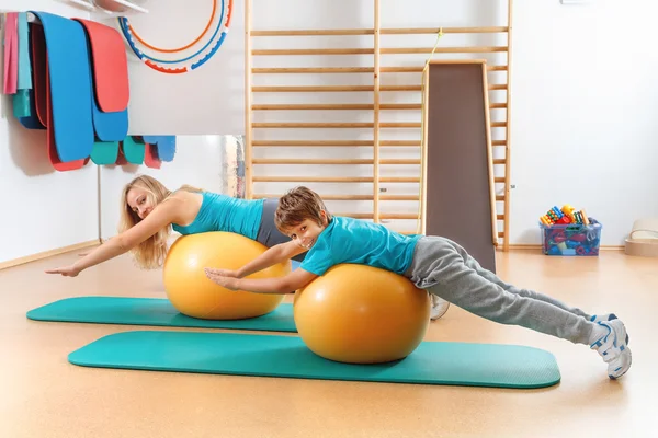 Happy, sports family, mother and son perform gymnastic exercises