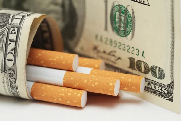 Cigarettes and money. expensive habit. white background - horizontal photo.