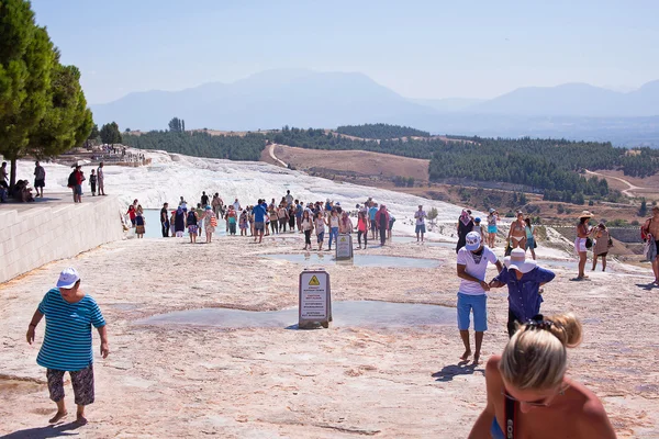 PAMUKKALE, TURKEY - September 13, 2015: Tourists regard the travertines with pools and terraces at Pamukkale. Pamukkale is included in the UNESCO World Heritage List