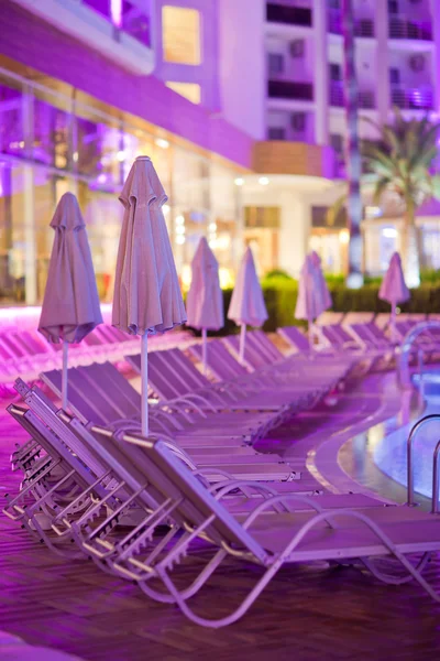 Chaise-longues by the pool in the evening