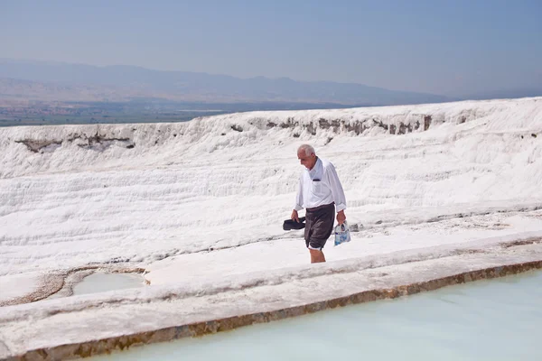 PAMUKKALE, TURKEY - SEPTEMBER 13, 2015: Unidentified tourist goes along travertine. It's a UNESCO World Heritage site