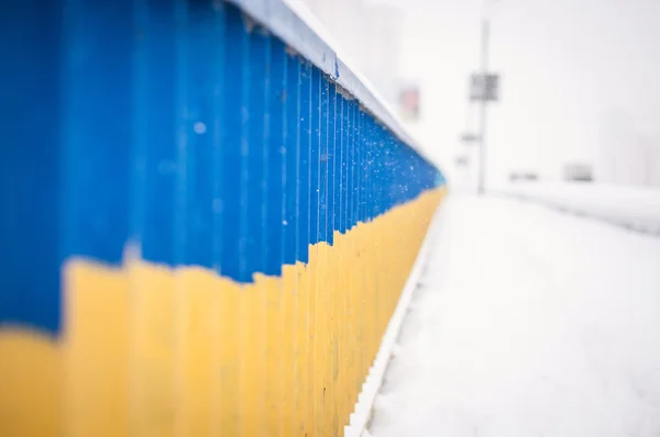 Patriotic Ukrainian flag on the bridge rails