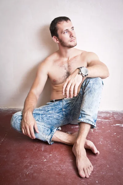Thoughtful attractive man sitting on the floor