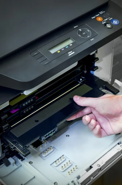 Man hand puts toner in the printer
