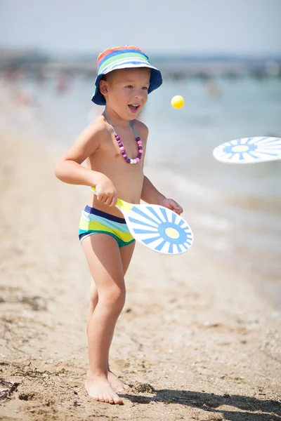 Young Boy Playing Paddle Ball on Sunny Beach