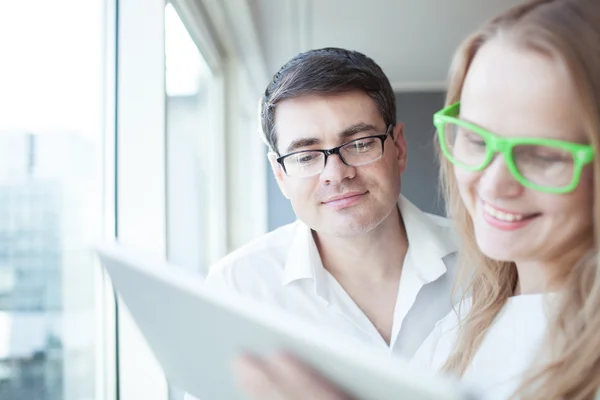 Happy businesspeople working with tablet PC in the office