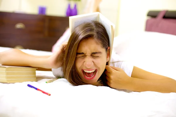 Girl tired of studying screaming with book on head