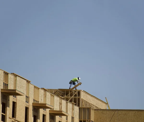 Construction on new building, man working on roof top