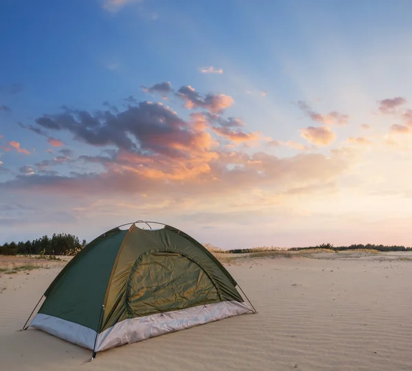 Green touristic tent on a sand