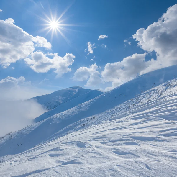 Winter snowbound mountain under a sparkle sun