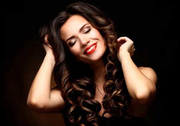 Beauty Model Woman with Long Brown Wavy Hair. Healthy Hair and Beautiful Professional Makeup. Red Lips and Smoky Eyes Make up