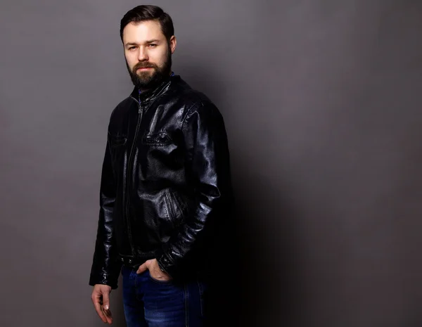 Attractive Young Man Wearing Leather Jacket on gray