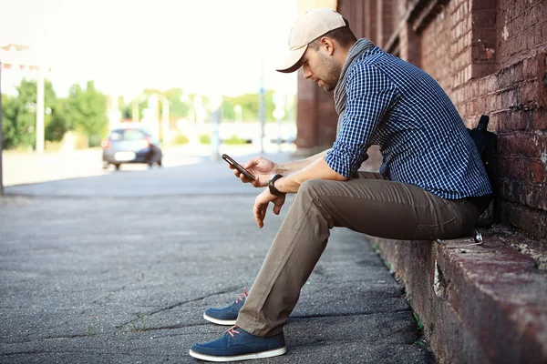 Young businessman professional on smartphone walking in street using app texting sms message on smartphone