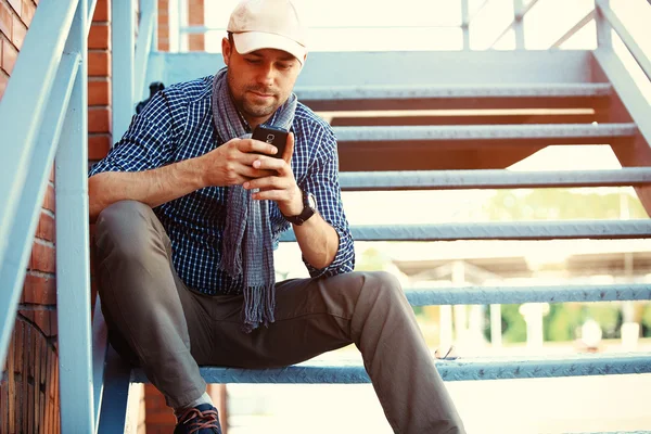 Young businessman professional on smartphone walking in street using app texting sms message on smartphone