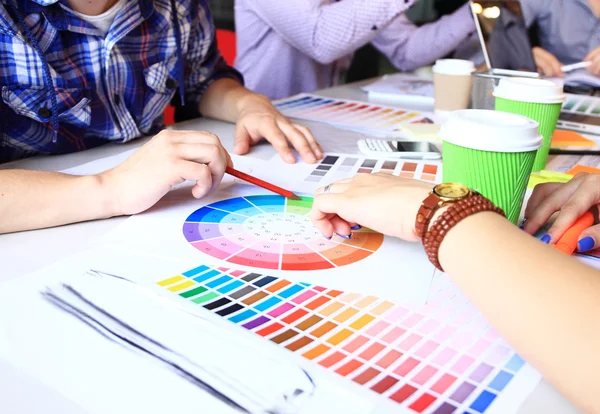 Creative people workplace. Close-up view of hands of young designer woman working with color palette at office desk. Attractive model choosing color samples for design project.