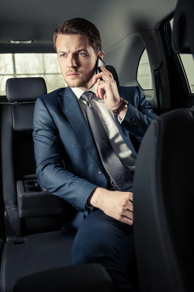 Businessman in the car with mobile phone