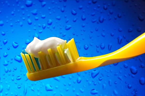 Toothbrush and toothpaste on blue background