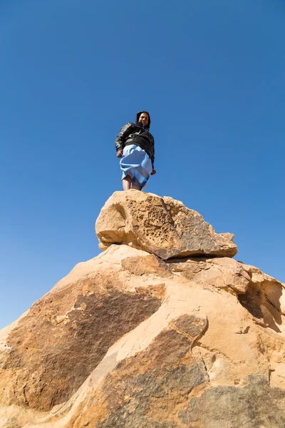 Tourist standing on rock in desert