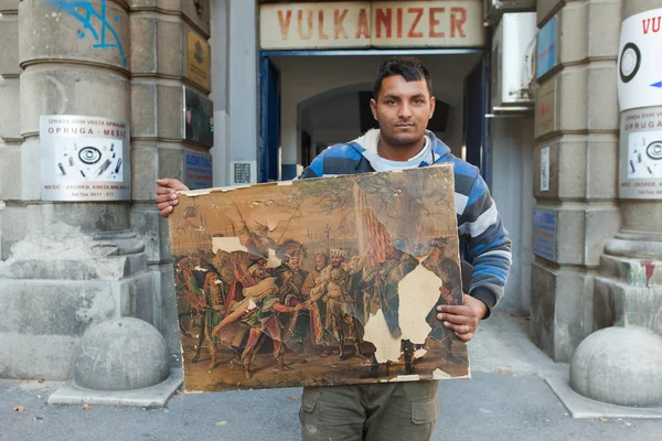 Man holding ruined painting