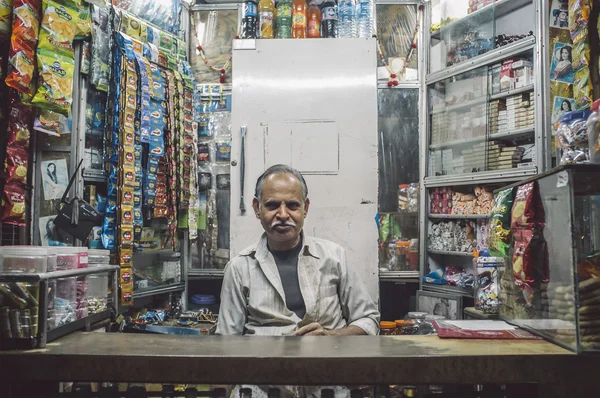 Indian vendor sits in shop