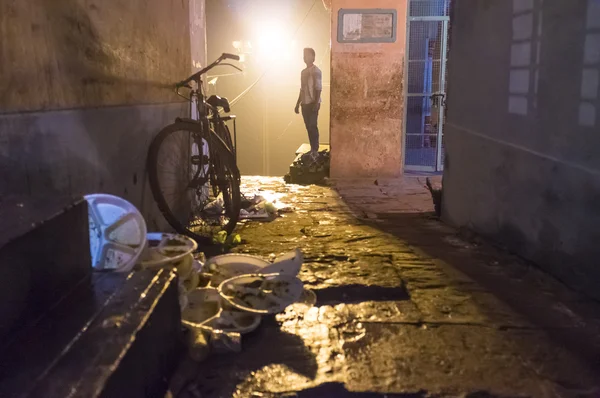 Indian man in street with parked bicycle