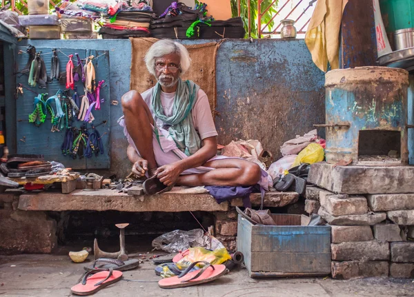 Indian vendor sits in street shop