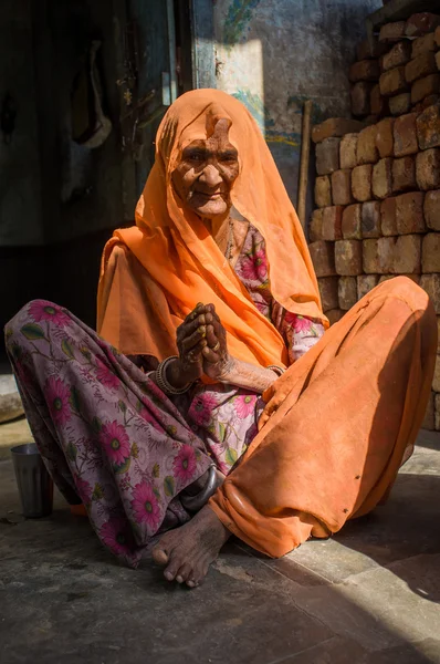 Elderly Indian woman sits