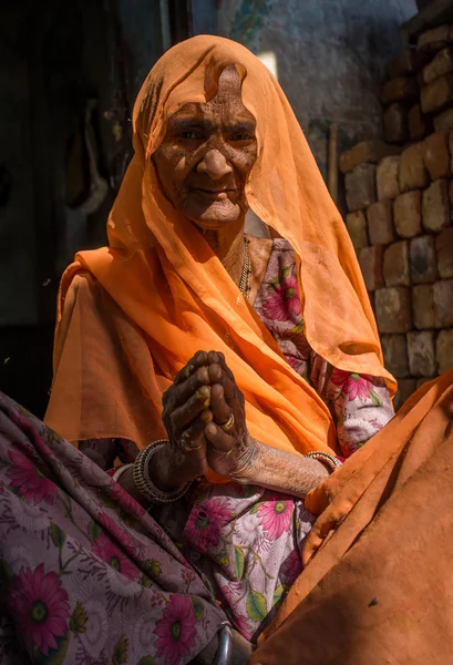 Elderly Indian woman sits in doorway