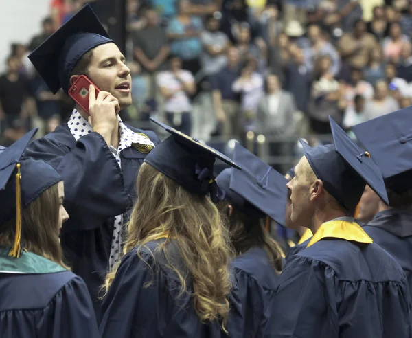 A Tall Man on a Cell Phone at His University Graduation