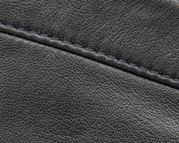 Dark gray leather background decorated with seam