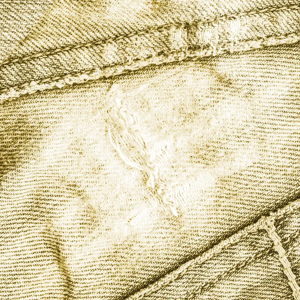 Detail of torn yellowish-green jeans