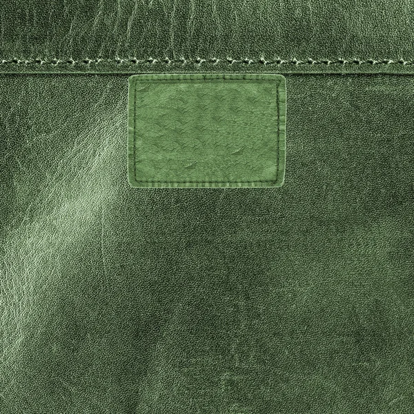 Green leather label on leather background. Textures