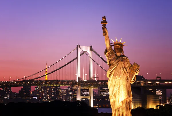 Tokyo skyline after sunset, statue of Liberty and Rainbow Bridge with cityscape at Odaiba island,Japan